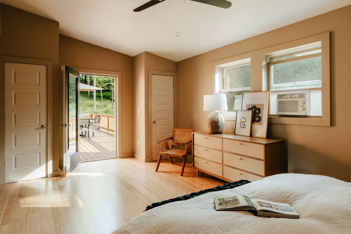 Camera da letto con luce naturale e vista sulla foresta.